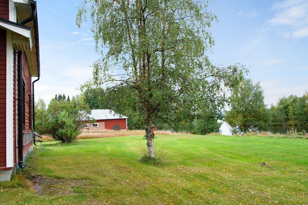 Huvudbyggnadens vita knut med vy över tomtens härliga baksida med dess makalösa läge.
